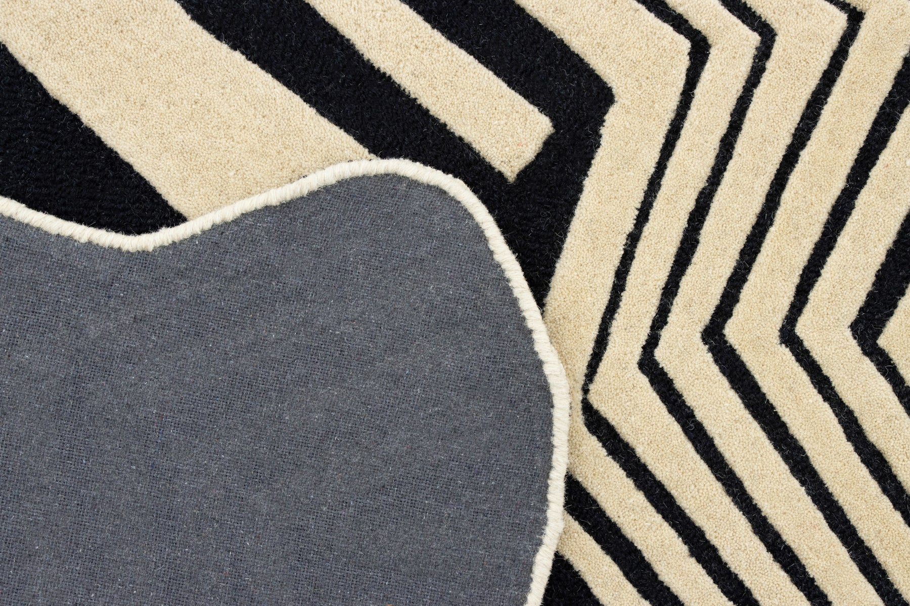 Grey cotton back of black beige irregular rug | Beyond Rugs USA