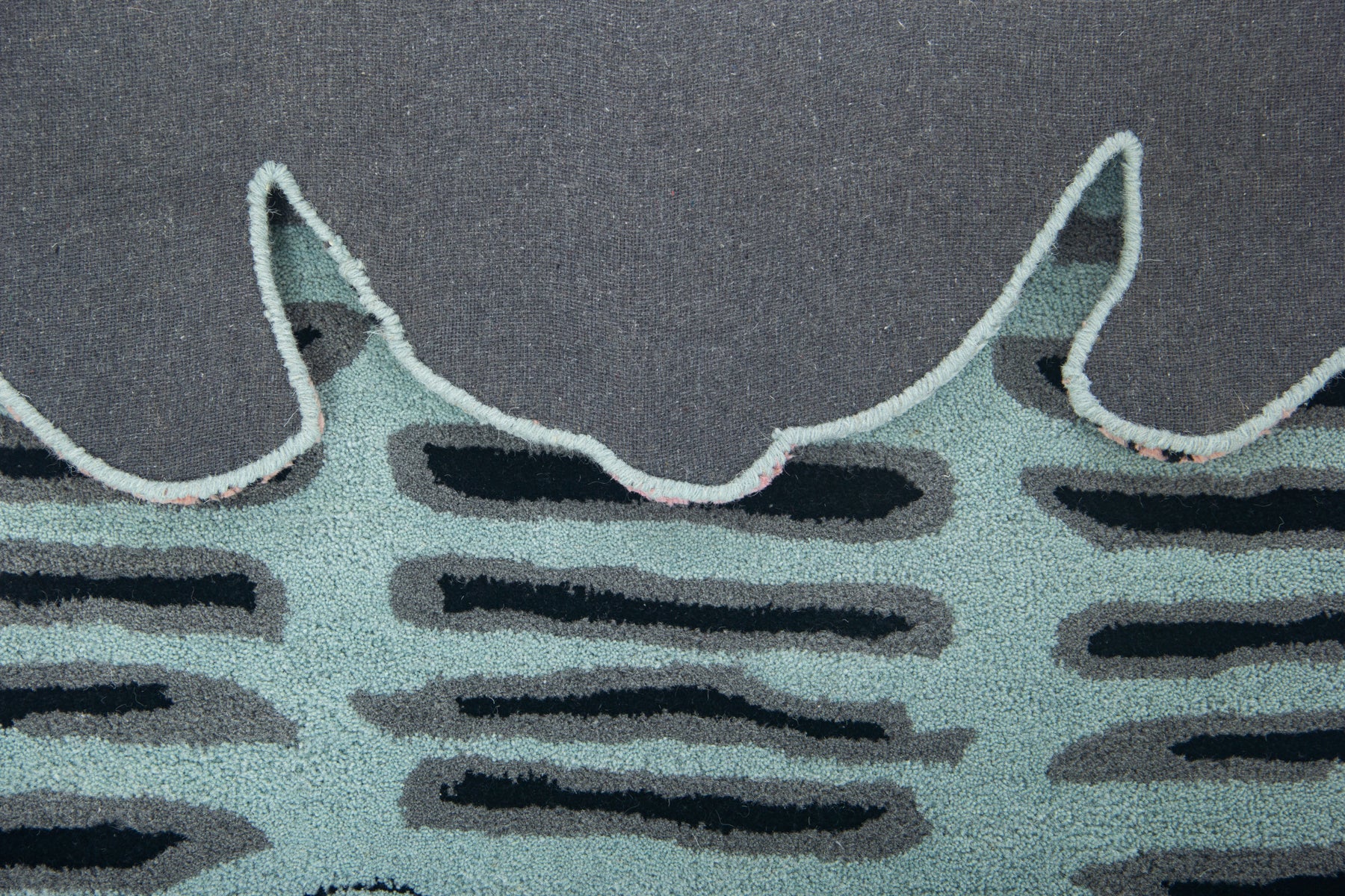 Back of flat cat rug showing grey canvas with cat ear cut-out edges and turquoise pile | Beyond Rugs