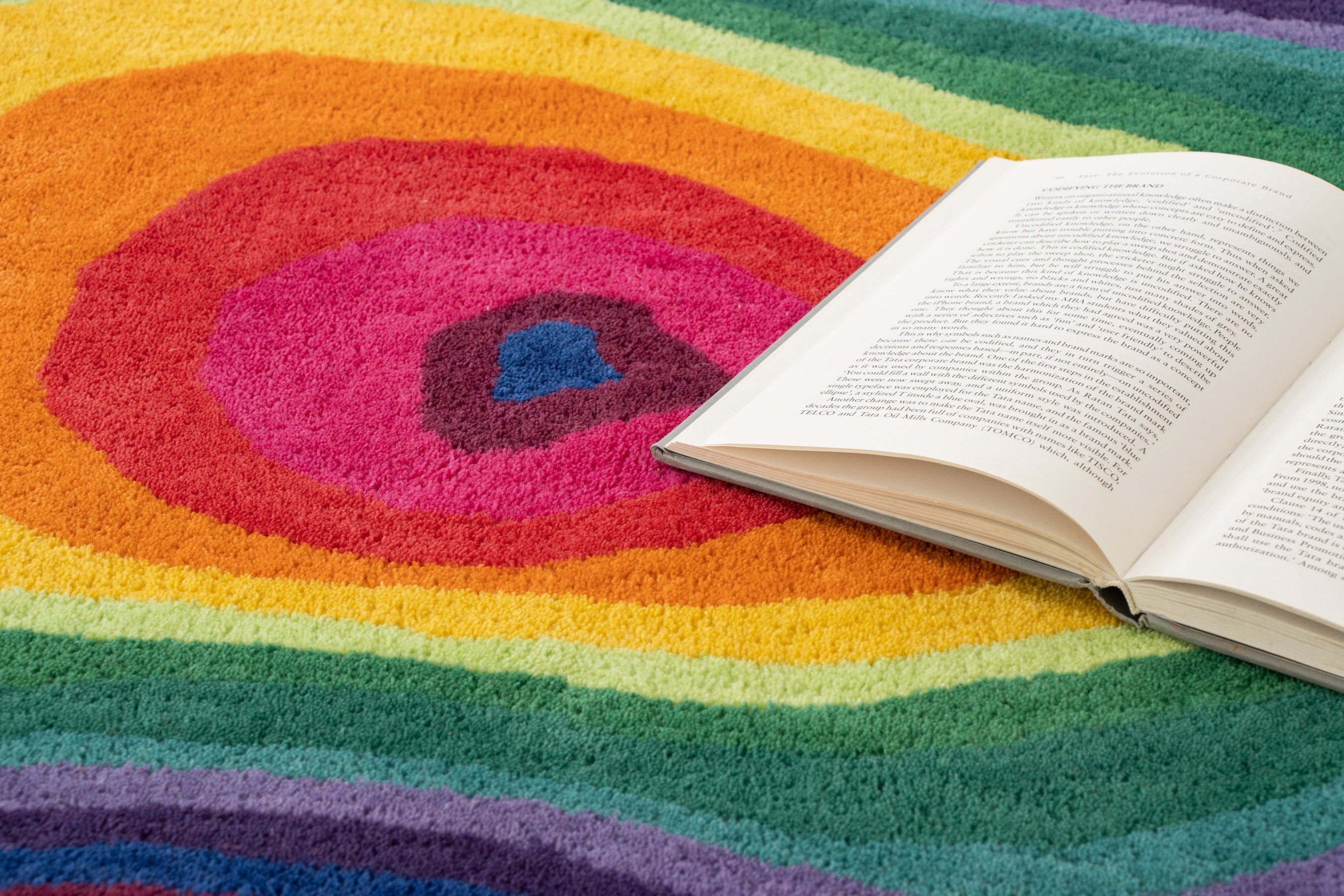 Paint Melts Rhapsody rug flat lay with open book detail - lifestyle product photography showing texture and colors