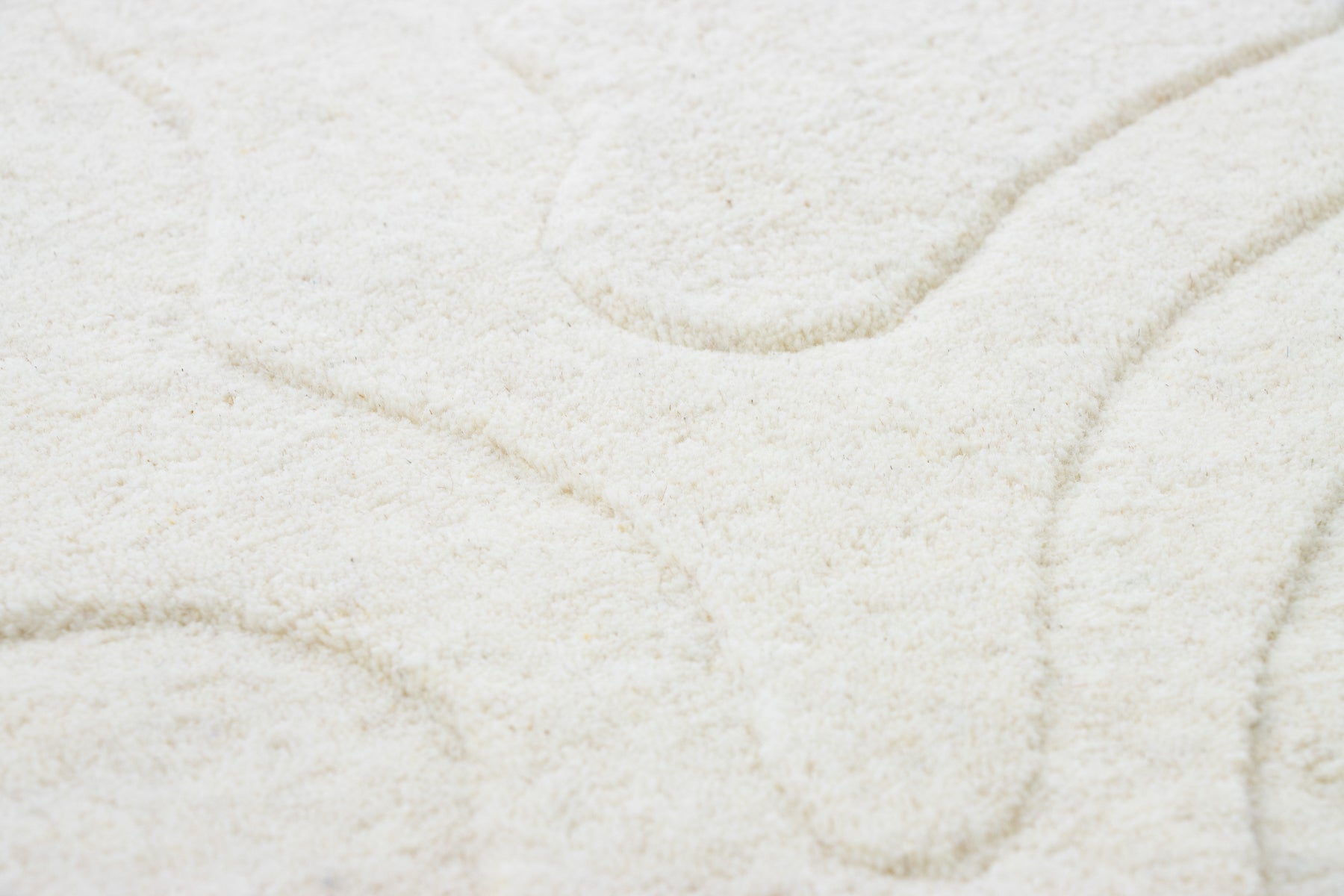 Close-up of Amoeba Polar wool pile showing ivory tonal wave pattern, medium pile | Beyond Rugs