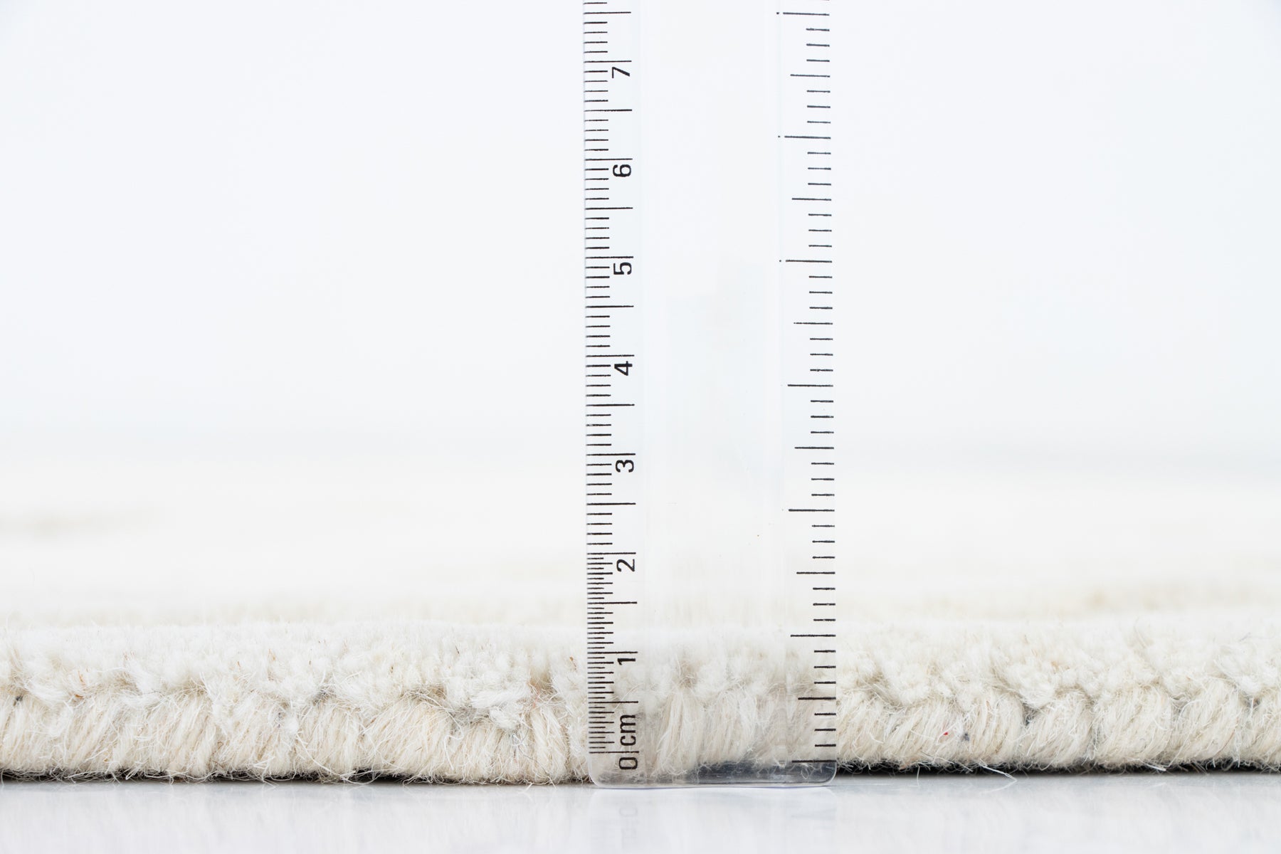 Amoeba Polar rug side profile with ruler showing 12–15mm wool pile height