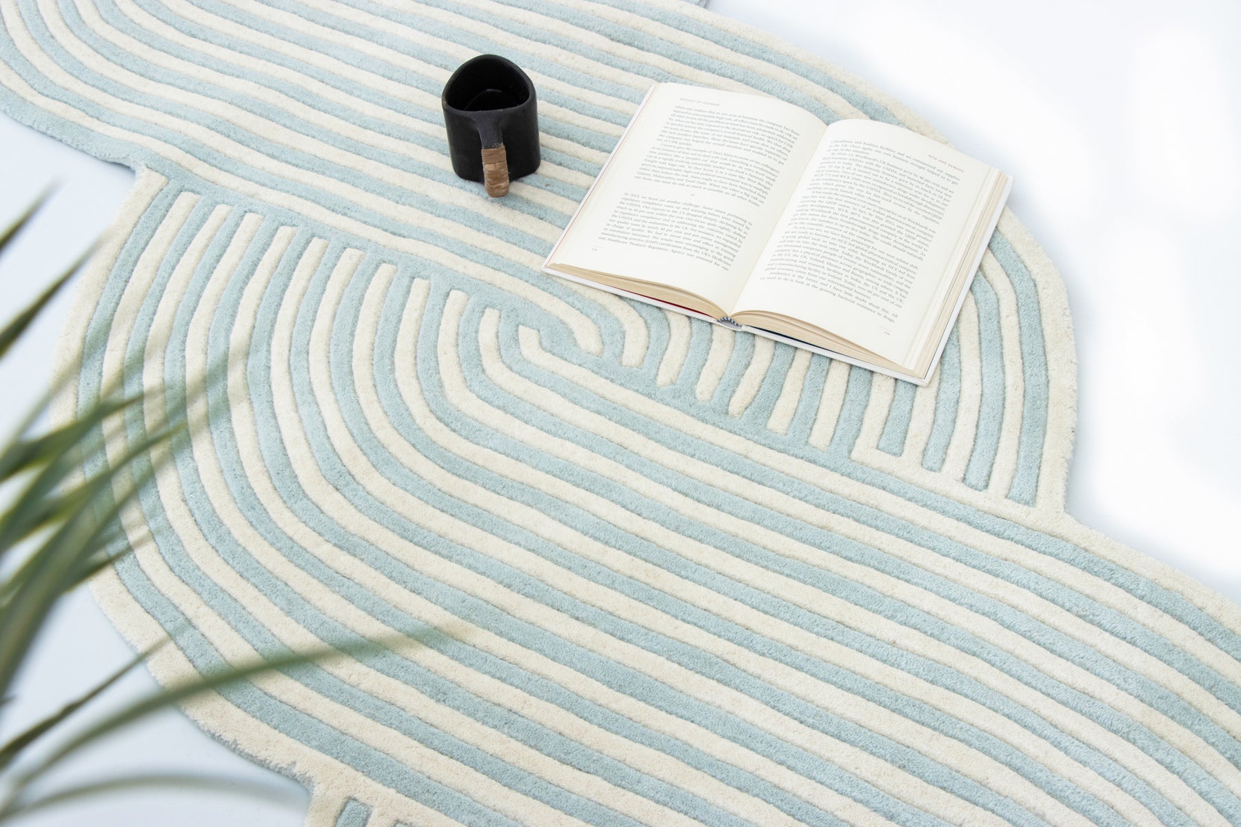 Open book on blue irregular braided wool rug | Beyond Rugs USA