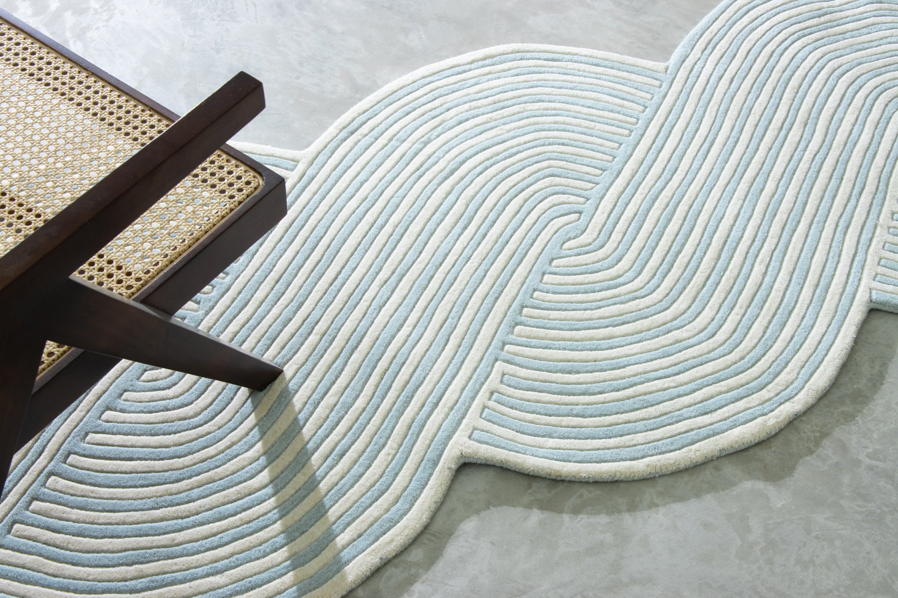 Wooden chair on blue irregular braided area rug | Beyond Rugs USA