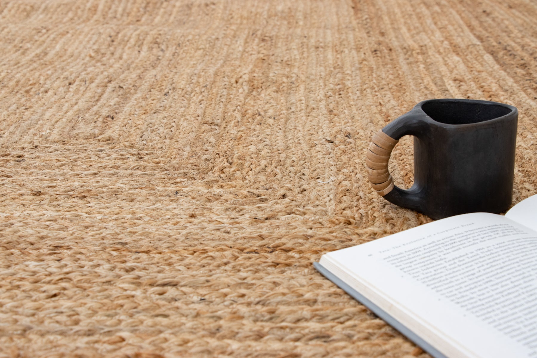 Black mug and open book on a textured brown surface