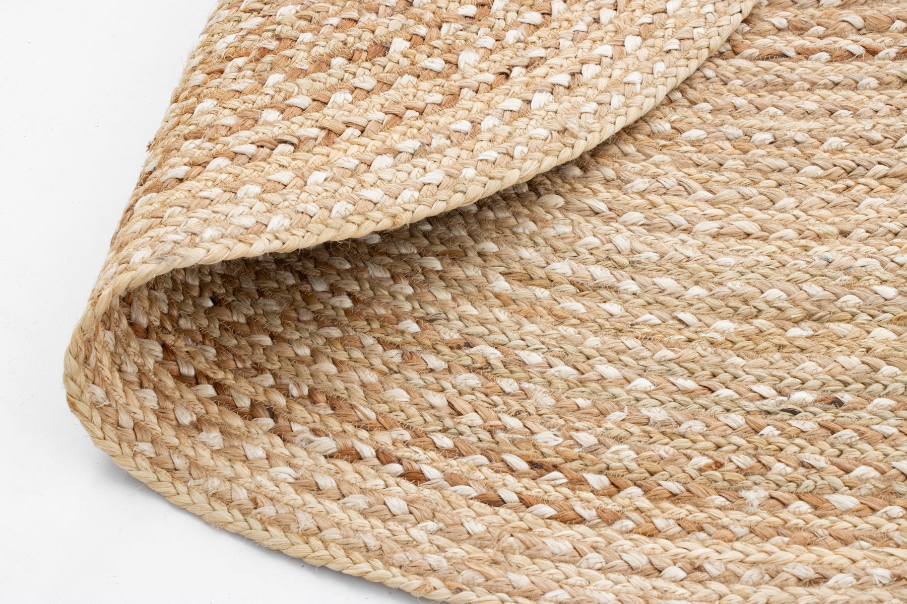 Close-up of a woven jute rug on a plain background.