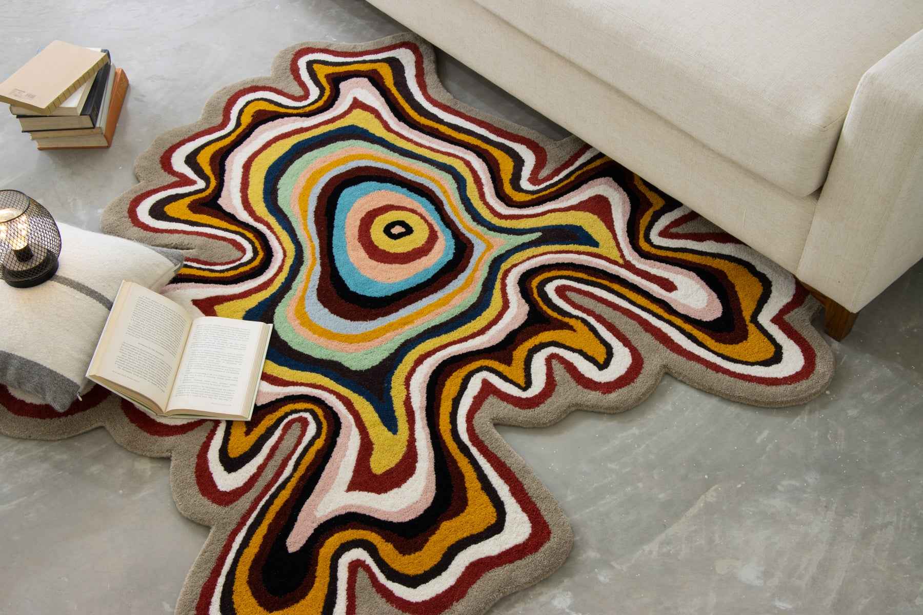 Paint Melts irregular area rug styled beside a sofa in a cozy living room