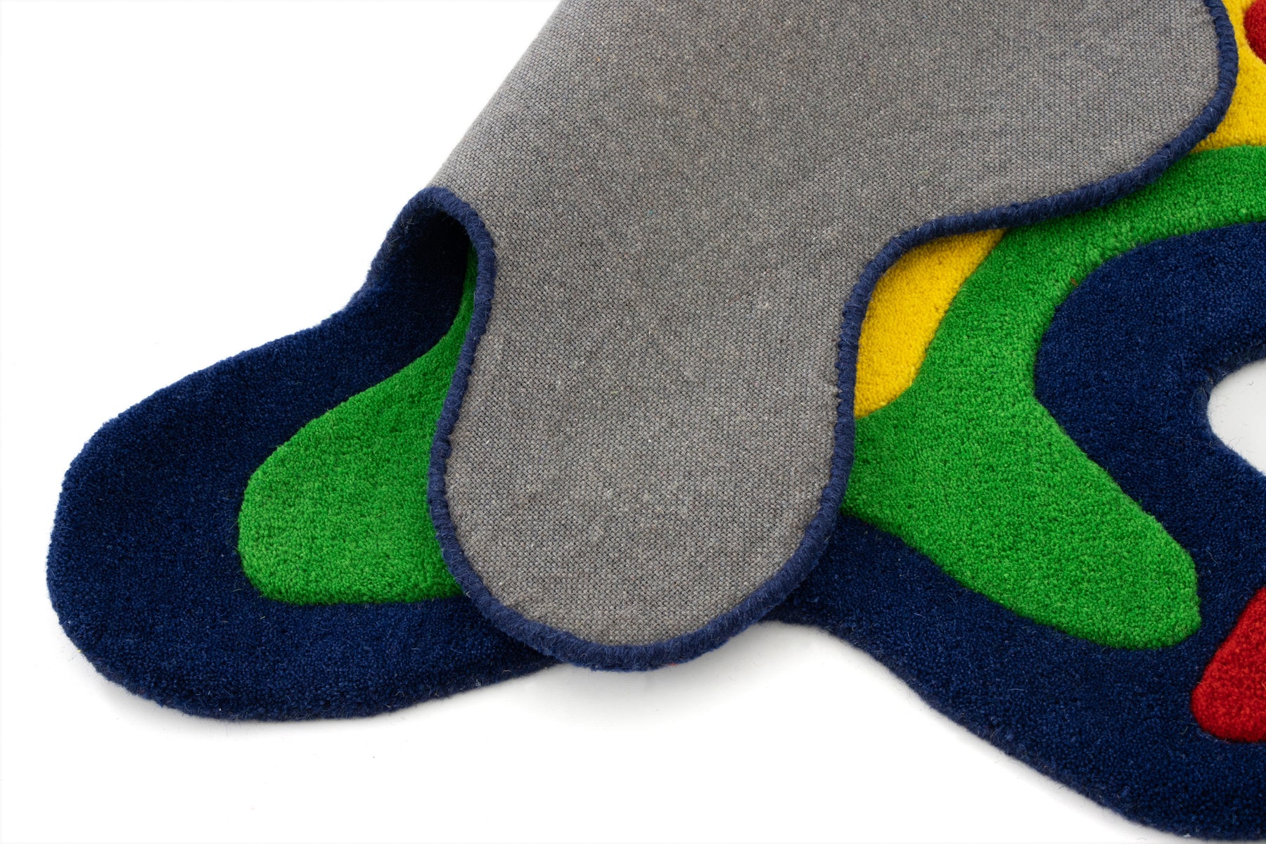Amoeba Thermal rug folded showing grey canvas backing and multicolor pile face | Beyond Rugs