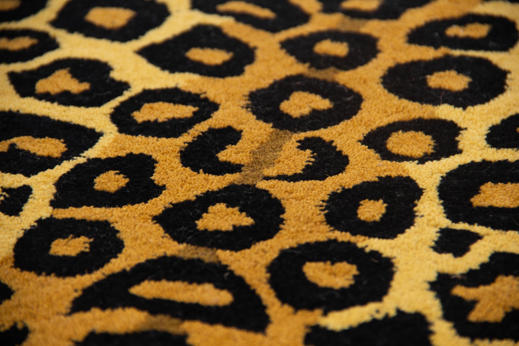 Close-up of golden yellow black spot texture on classic leopard hand tufted wool rug | Beyond Rugs