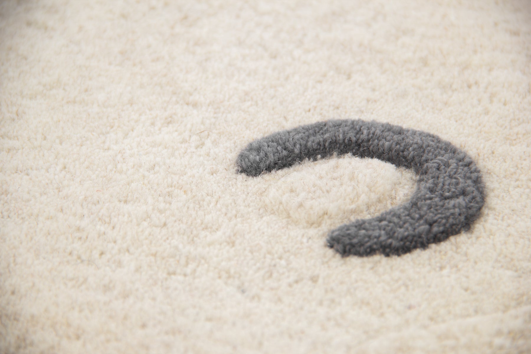 Detail view of grey claw marks on ivory polar bear hand tufted irregular wool rug | Beyond Rugs