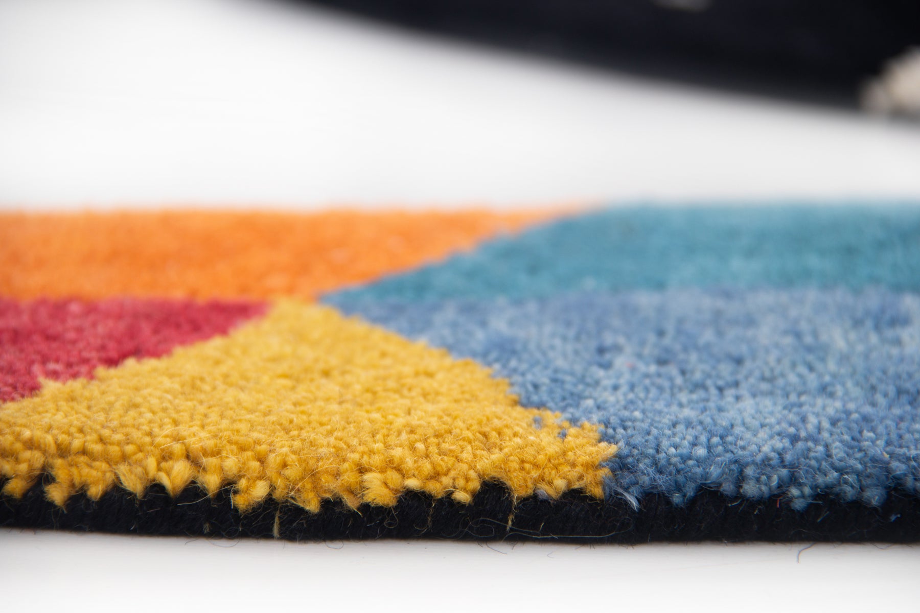 Close-up of hand tufted wool texture on tropical toucan rug with multicolor details | Beyond Rugs