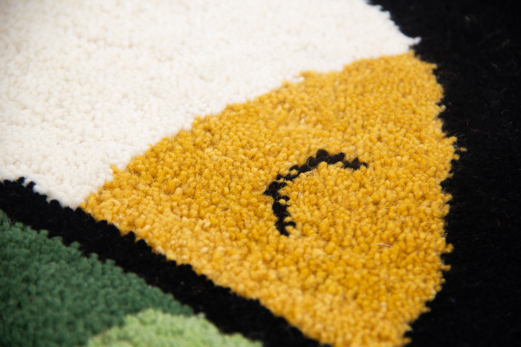 Detail shot of colorful toucan beak on black wool irregular shaped bird silhouette rug | Beyond Rugs