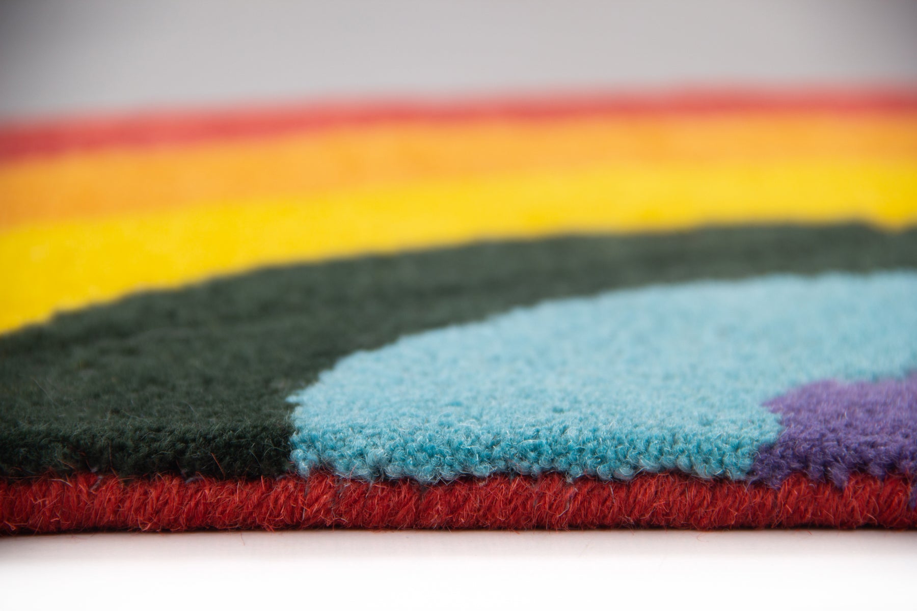 Side profile of Cassata multicolor rainbow arch rug showing pile depth and irregular edge | Beyond Rugs