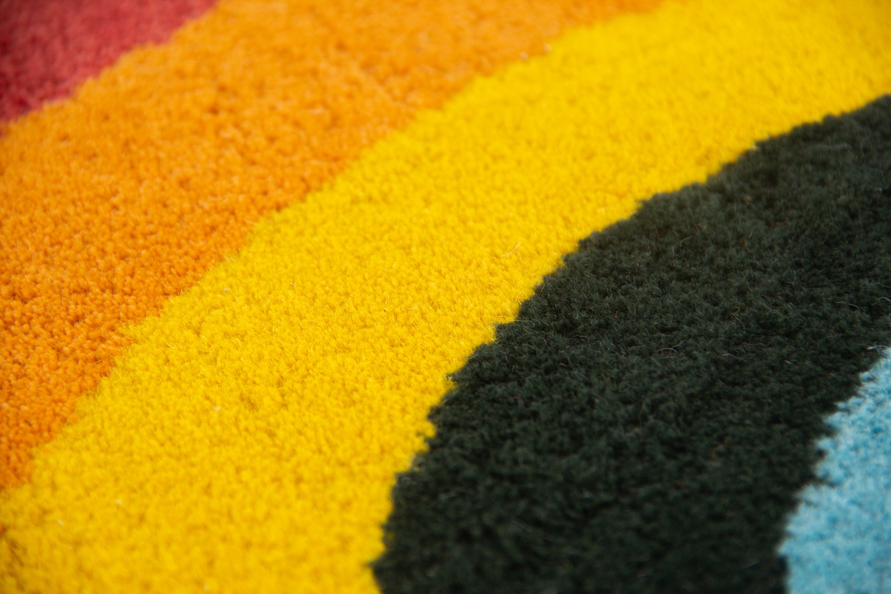 Macro wool texture of Cassata rug showing bold yellow and black hand tufted stripe detail | Beyond Rugs