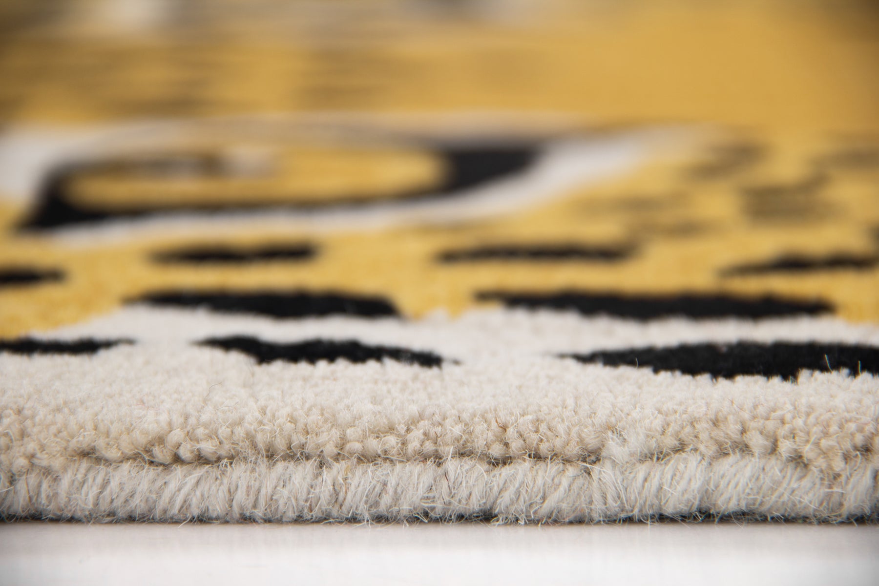 Flat lay of leopard print circular rug in golden yellow and black, handmade wool rug | Beyond Rugs