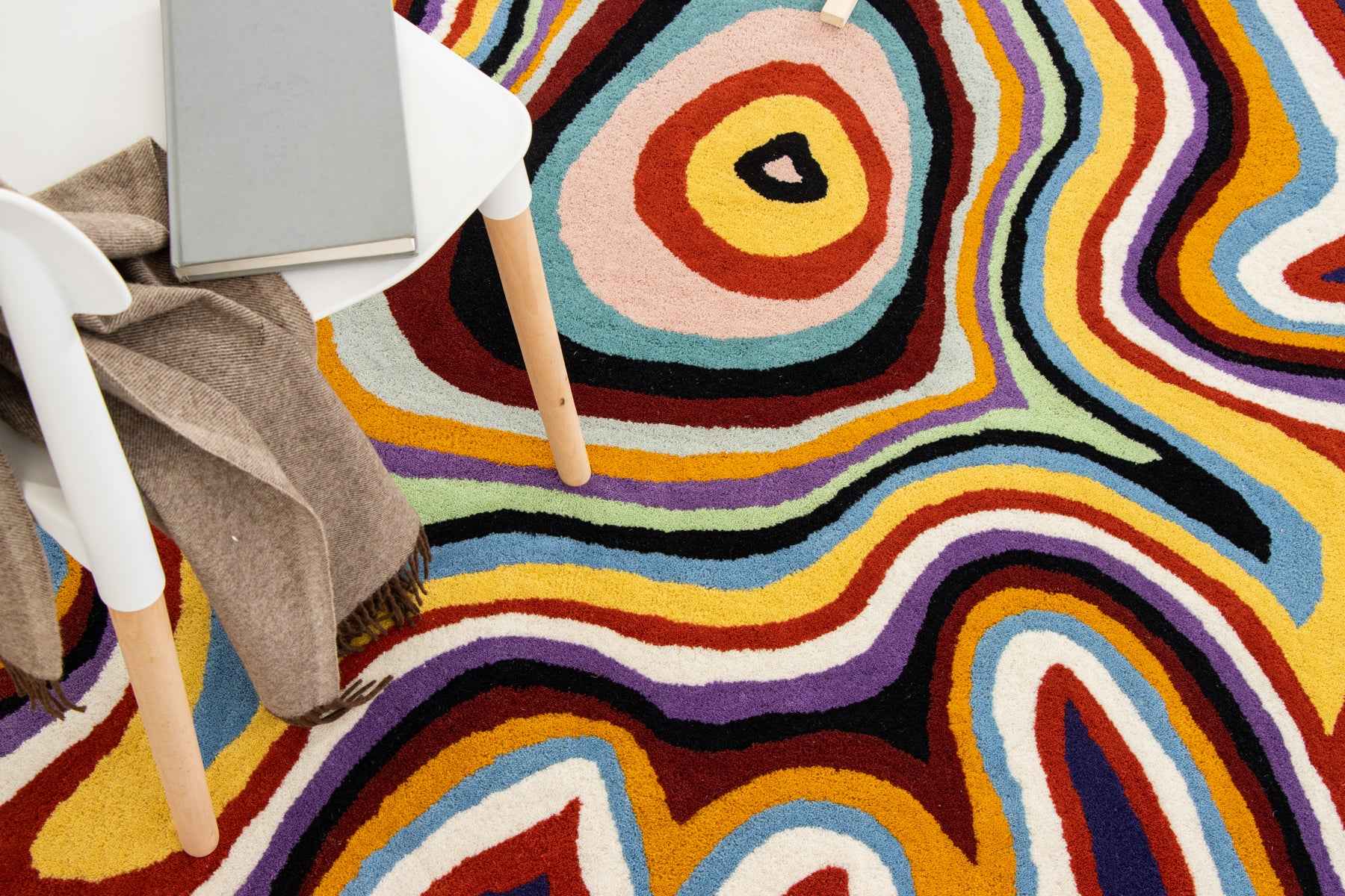 Paint Melts Radiant irregular rug styled with minimalist furniture - full room view showing rug placement