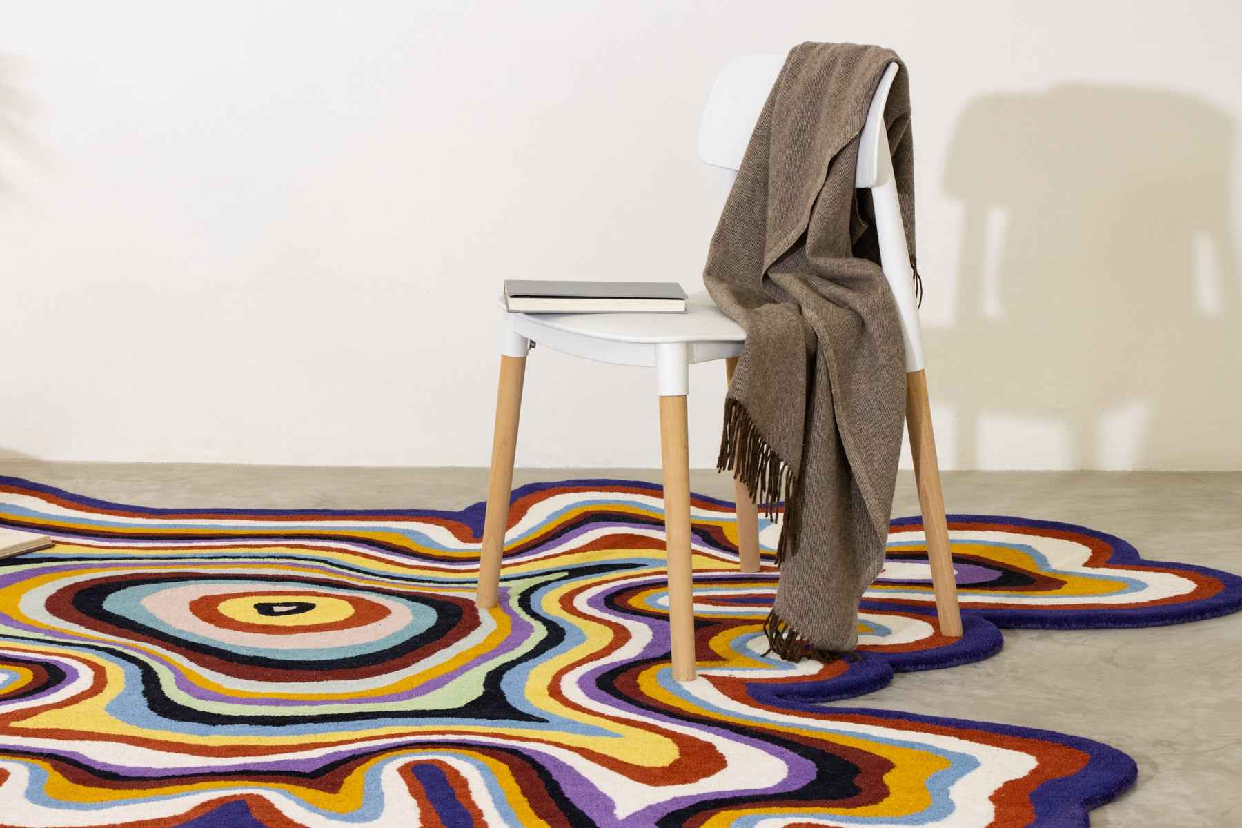 Overhead view of Paint Melts Radiant rug corner detail - multicolor swirling pattern on white background