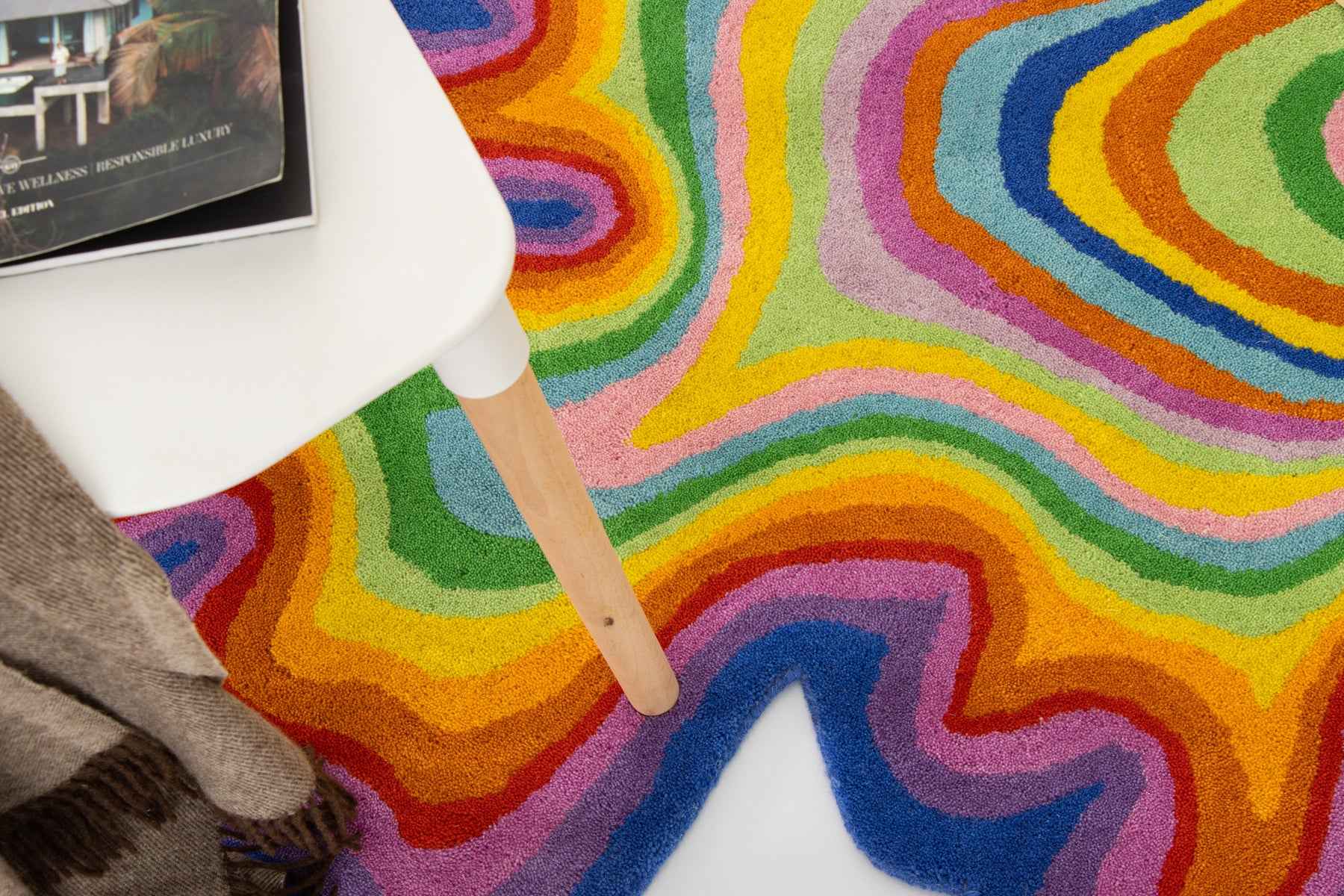 Psychedelic rug wide flat-lay with Rubik's cube, books and woven cushion | Beyond Rugs