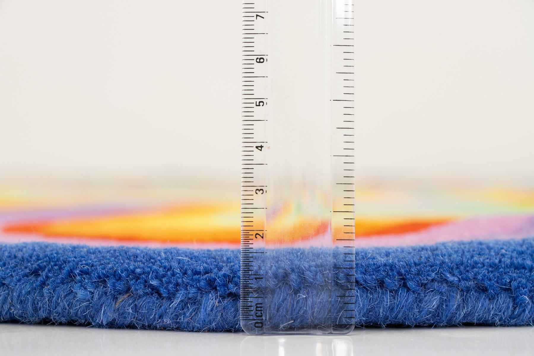 Psychedelic rug side profile with ruler showing 12–15mm blue and orange wool pile | Beyond Rugs