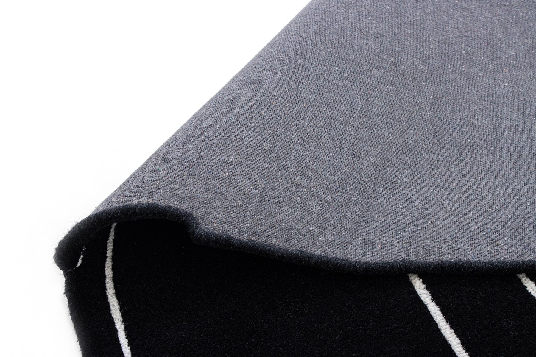 Grey cotton backing of black irregular rug | Beyond Rugs USA