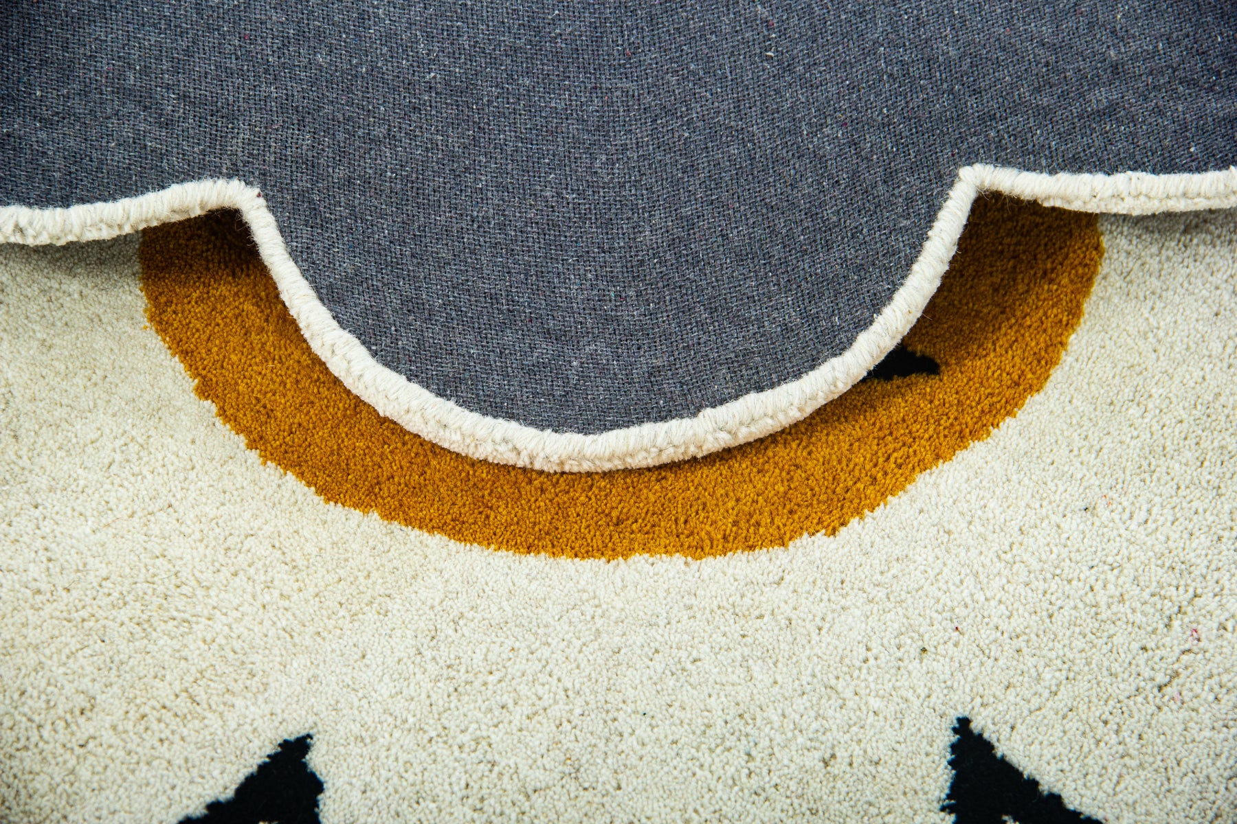 Back canvas of flower emoji rug showing grey lining and irregular daisy cut-out edge | Beyond Rugs