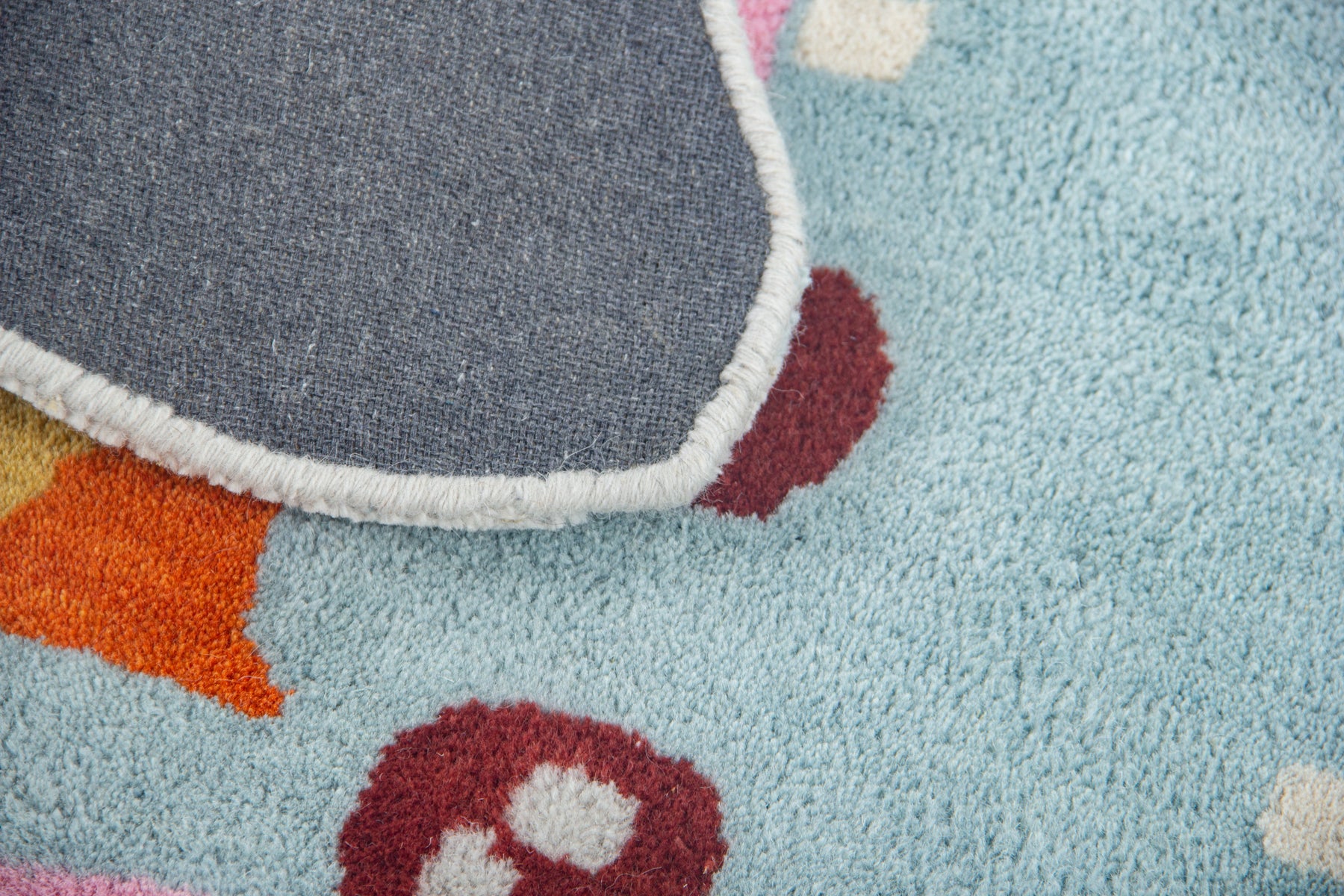 Back of blue starfish rug showing grey canvas, white fringe and cut-out star silhouette | Beyond Rugs