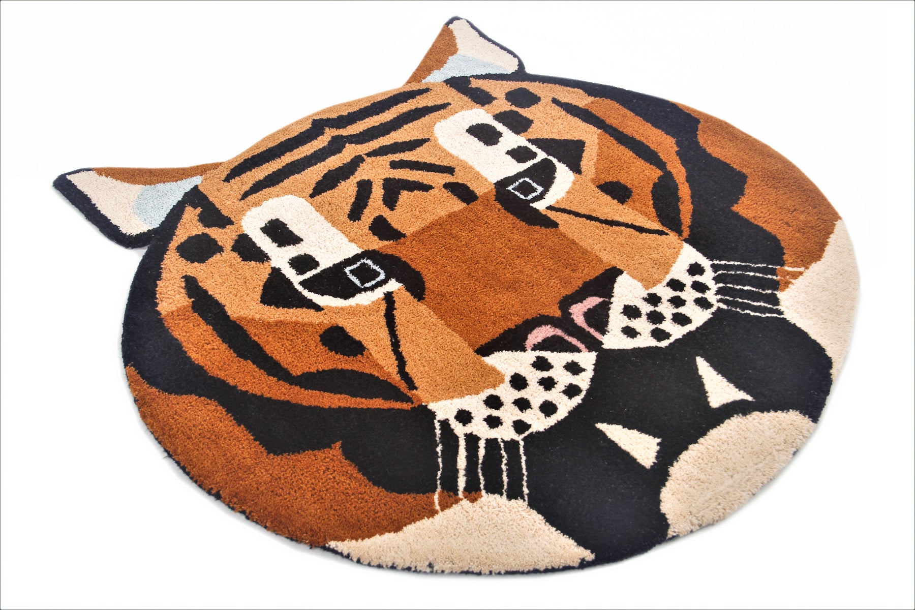 Angled view of circular tiger head wool rug in orange and black, irregular cut silhouette | Beyond Rugs