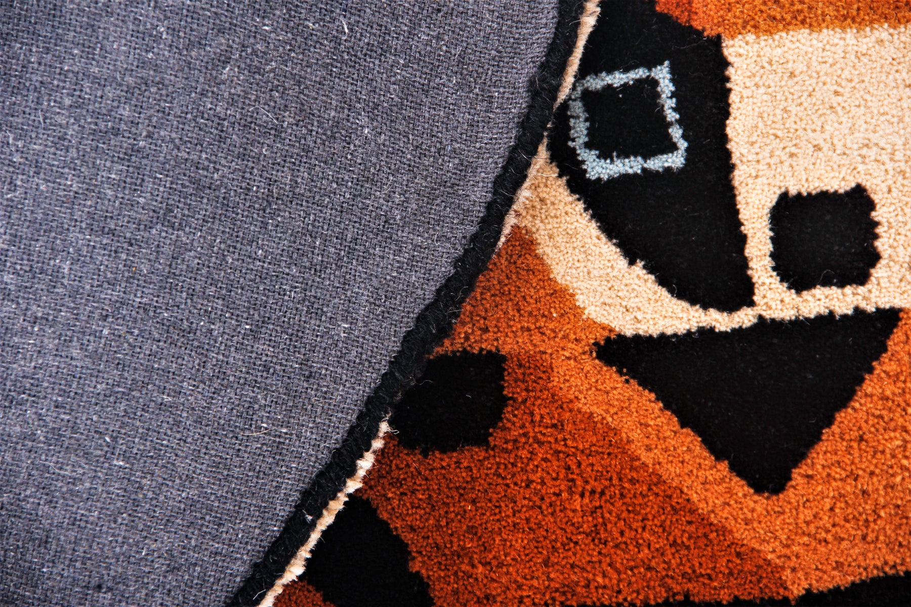 Back texture of tiger head circular rug showing grey canvas and irregular shaped edges | Beyond Rugs