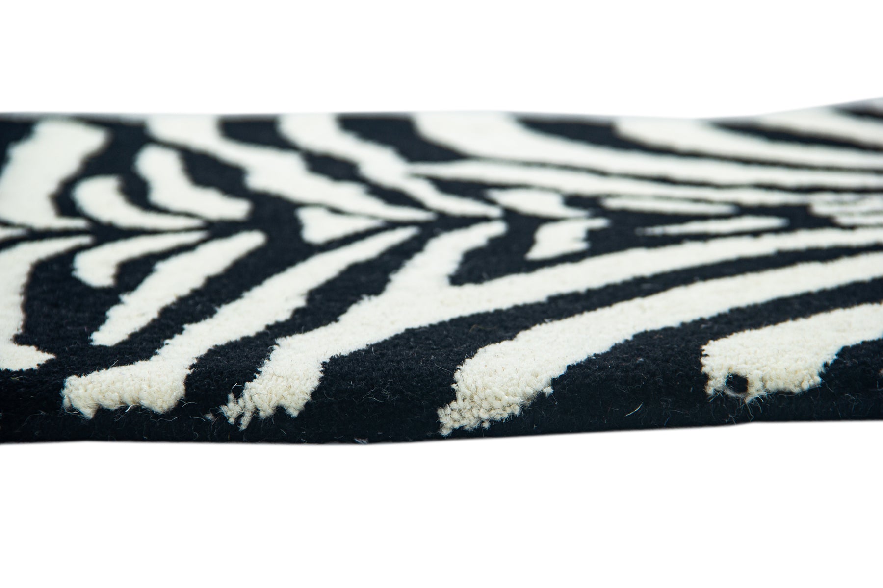 Side angle of black white zebra kid wool rug showing irregular silhouette shaped edges | Beyond Rugs