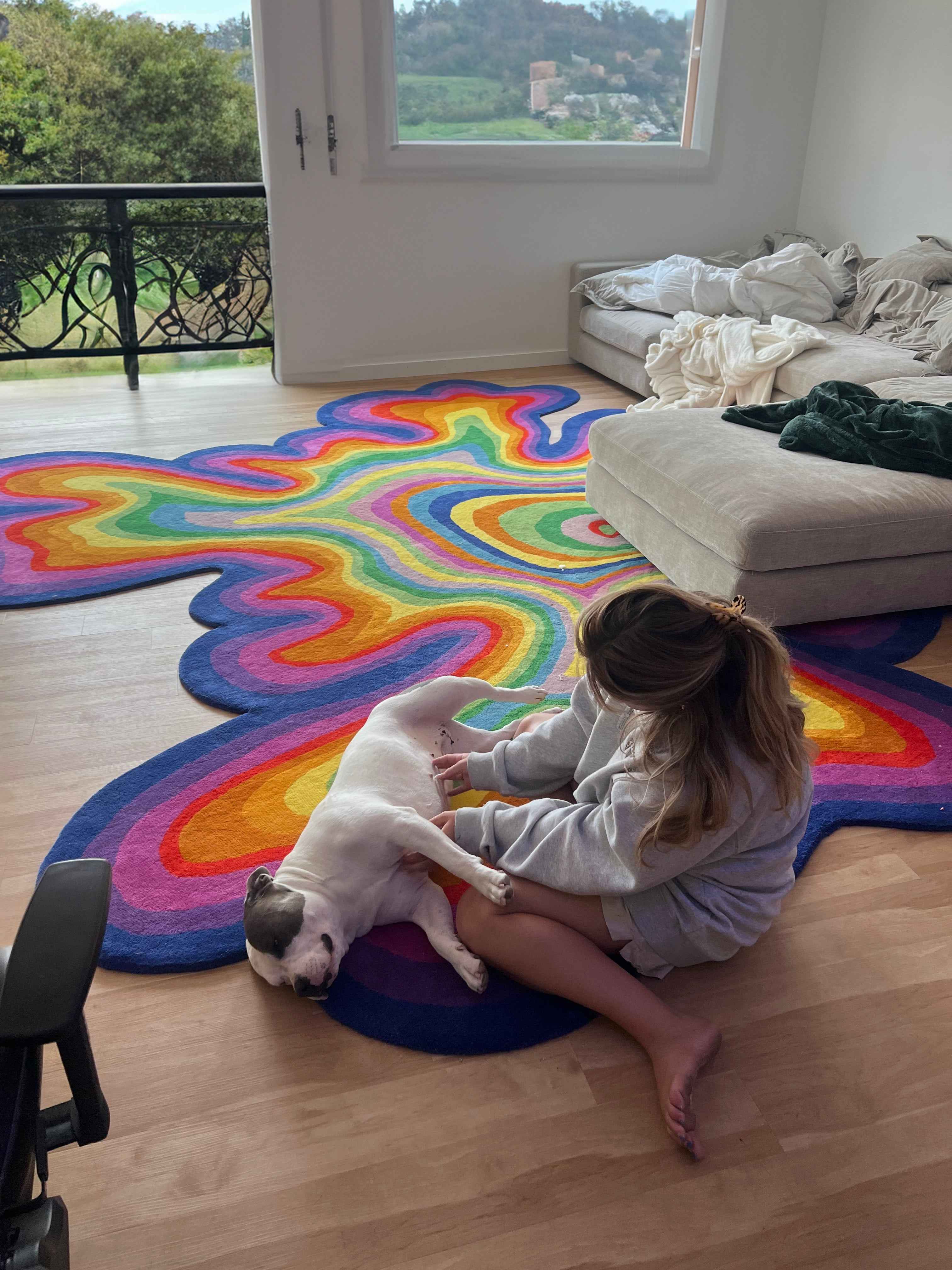 Customer photo: girl with white dog sitting on Psychedelic rug in bright living room | Beyond Rugs